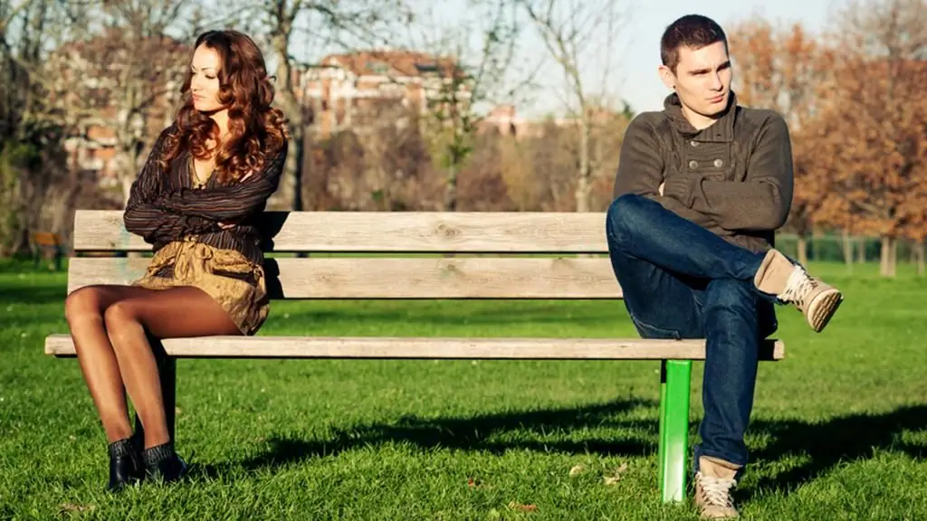 Young spouses in a quarrel on a bench