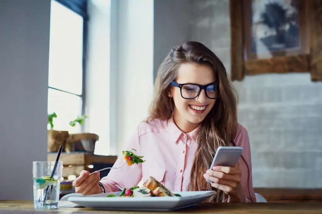 Gadis menyemak imbas mesej semasa makan tengah hari