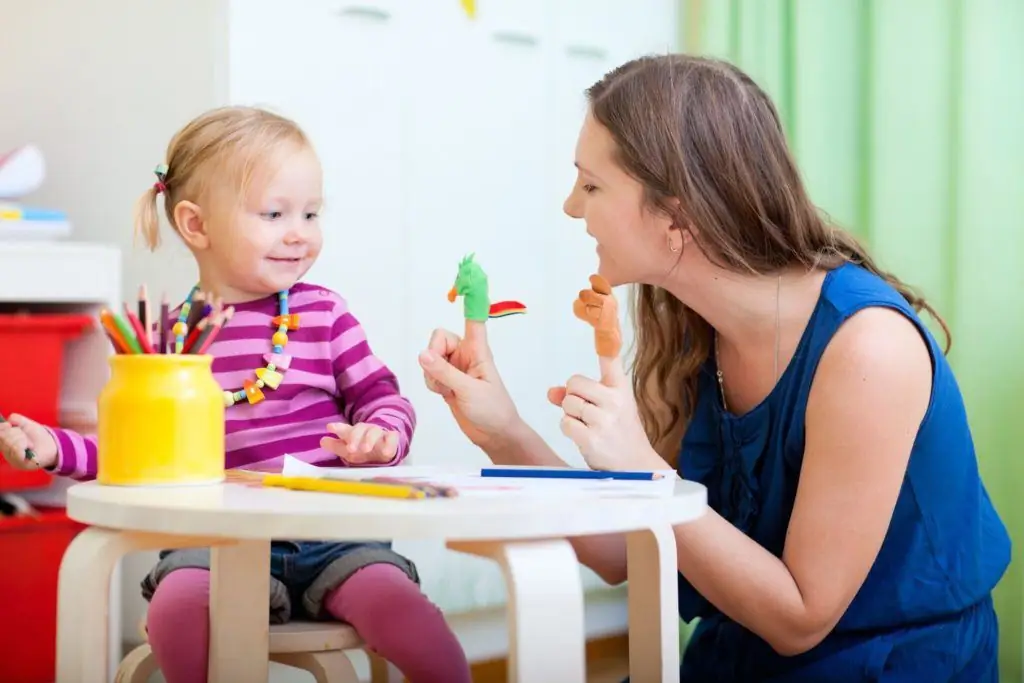 girl sitting at the table with the teacher