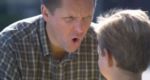 a man in a plaid shirt yelling at a boy