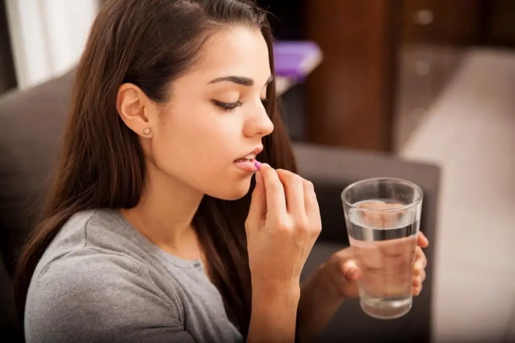 The girl drinks a pill for arousal