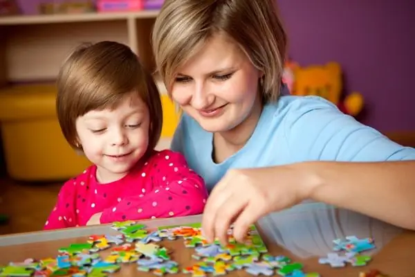 mother and daughter put together a puzzle