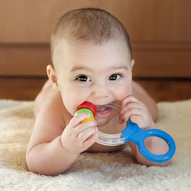 Baby chewing on a rattle