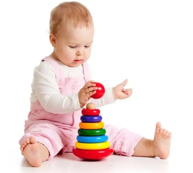 Six month old baby girl playing with a pyramid