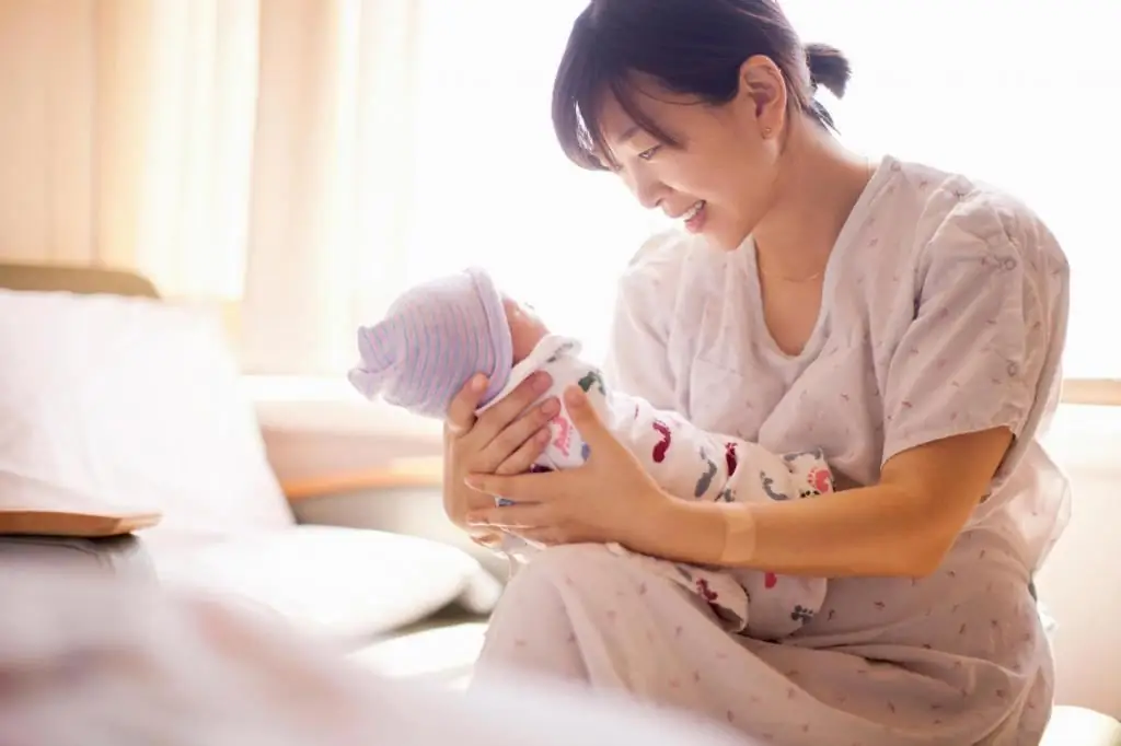 woman holding a newborn baby in her arms