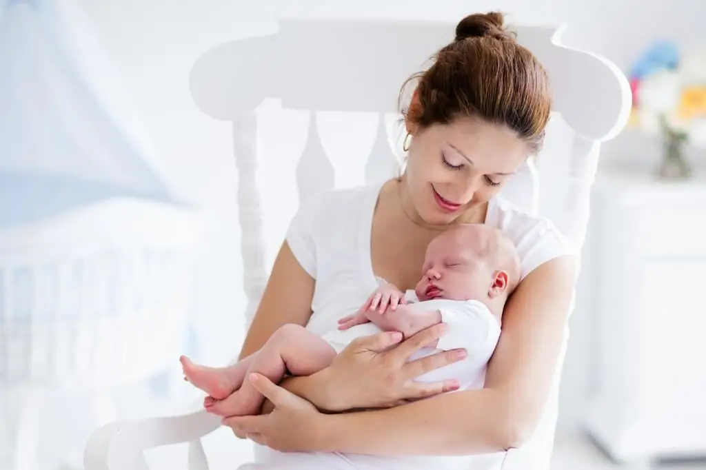 mãe coloca o bebê para dormir