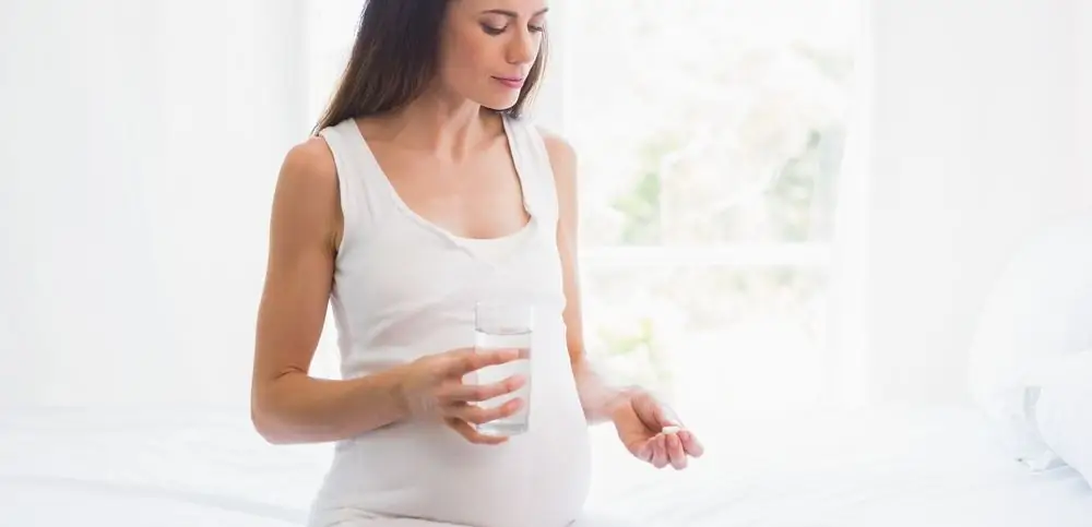 Gravid kvinna tar vitaminer