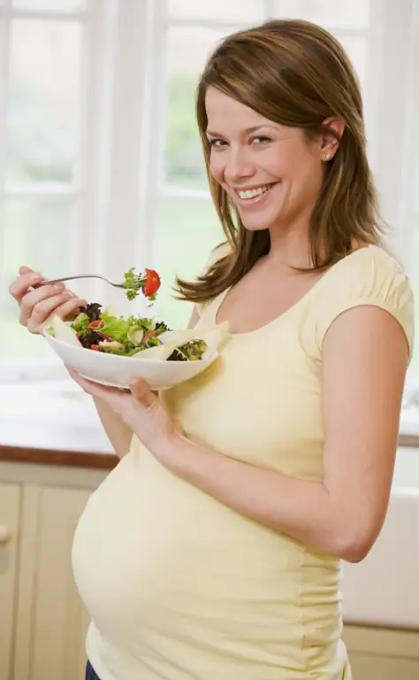 Chica embarazada con ensalada